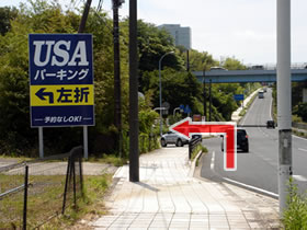 ④USAパーキング左折の青い看板が見えましたら、その先の道を左折です。
